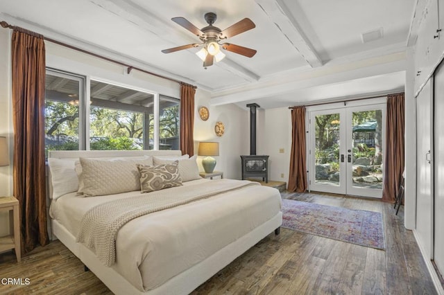 bedroom with french doors, beam ceiling, a wood stove, dark hardwood / wood-style floors, and access to exterior