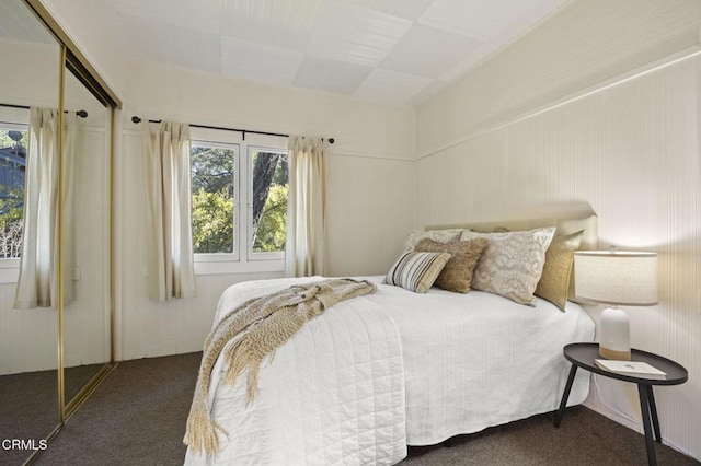 bedroom with dark carpet and a closet