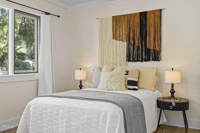 bedroom with crown molding and hardwood / wood-style flooring