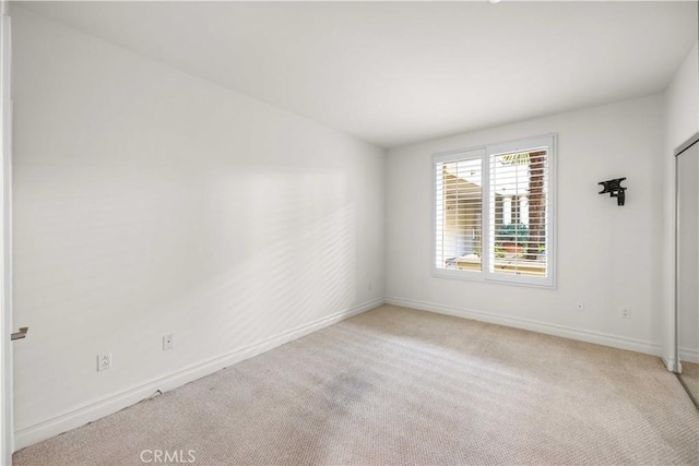 unfurnished room featuring light colored carpet