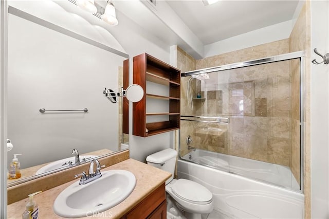 full bathroom featuring vanity, bath / shower combo with glass door, and toilet