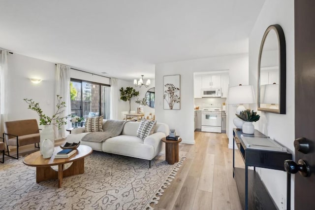 living room with a chandelier and light wood-type flooring