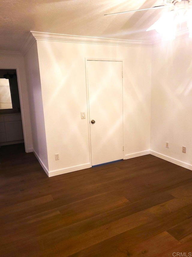 interior space featuring crown molding, ceiling fan, and dark wood-type flooring