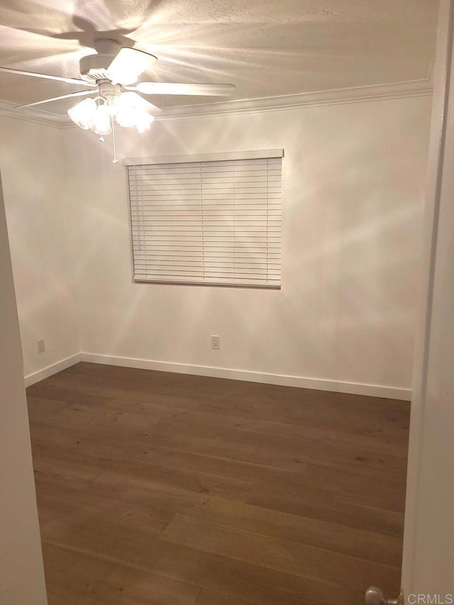 spare room featuring ceiling fan, crown molding, and dark wood-type flooring