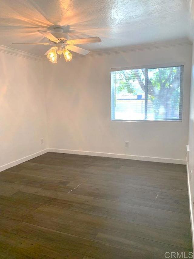 unfurnished room with dark hardwood / wood-style floors, ceiling fan, and crown molding