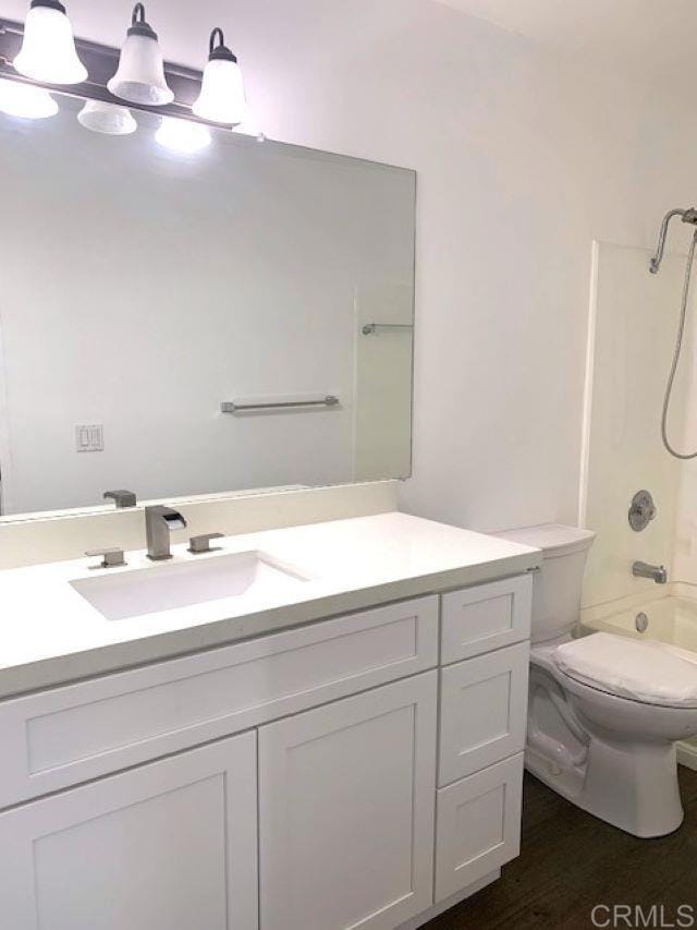 full bathroom with vanity, toilet, shower / tub combination, and wood-type flooring