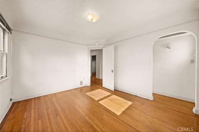 spare room with a textured ceiling and hardwood / wood-style flooring