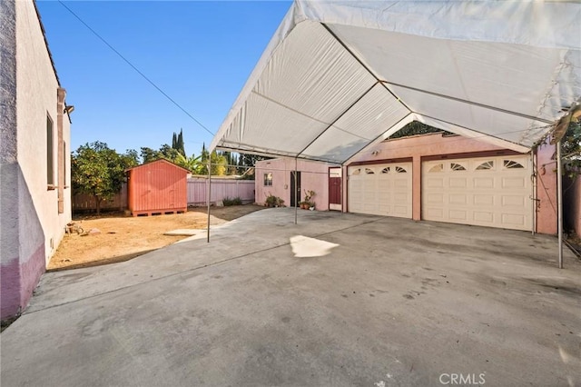 exterior space featuring a garage, a carport, and a storage shed