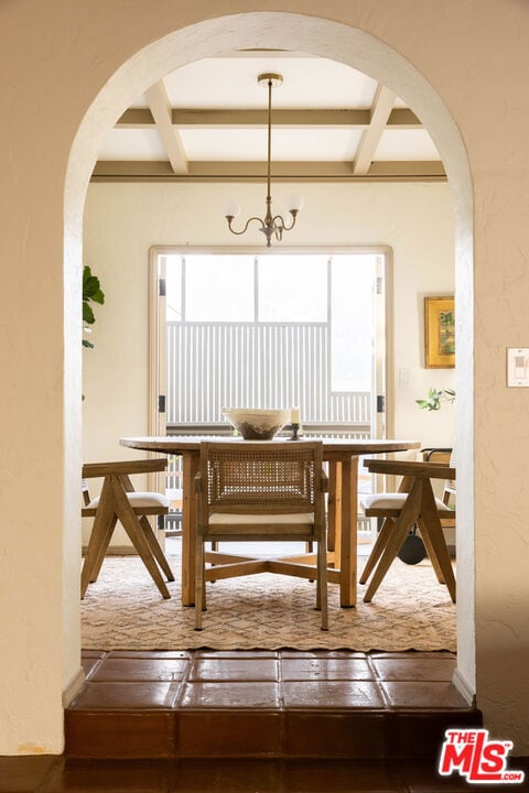 dining room featuring coffered ceiling, a notable chandelier, and beamed ceiling