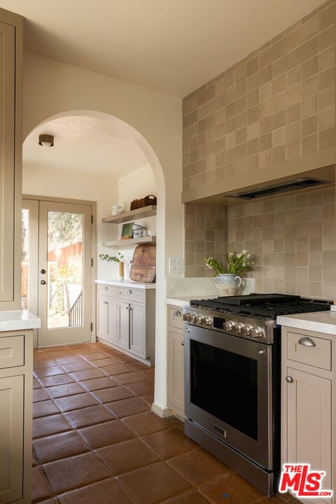 kitchen with tasteful backsplash, stainless steel range, and white cabinetry