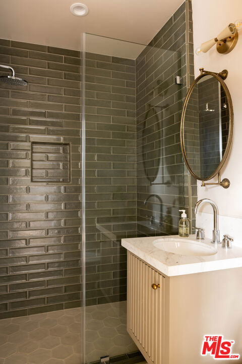 bathroom featuring walk in shower and vanity