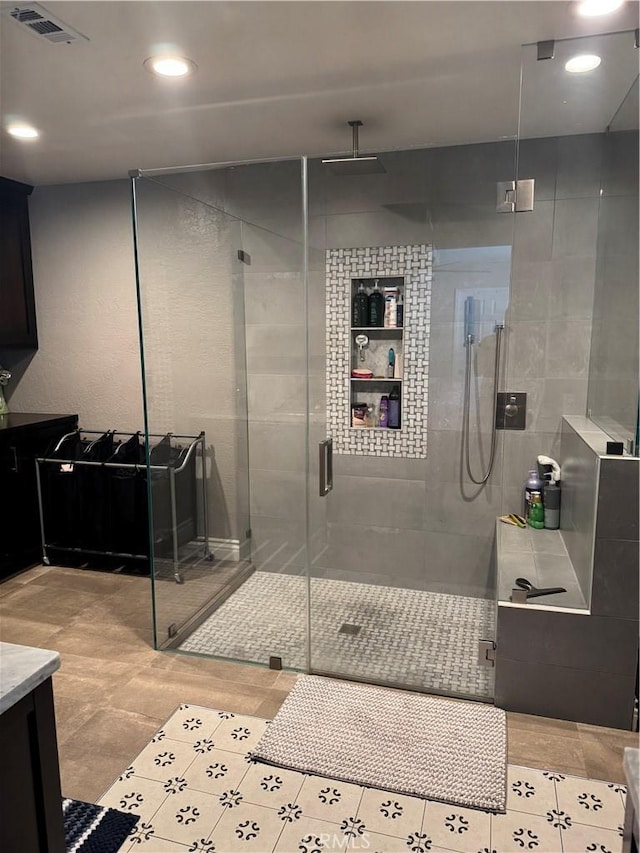 bathroom featuring a shower with door, tile patterned floors, and vanity