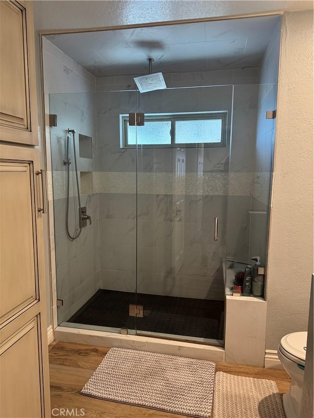 bathroom with toilet, wood-type flooring, and walk in shower