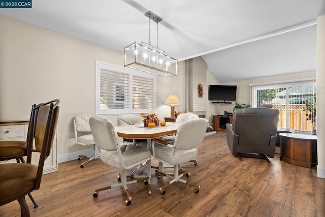 dining space featuring hardwood / wood-style flooring and vaulted ceiling