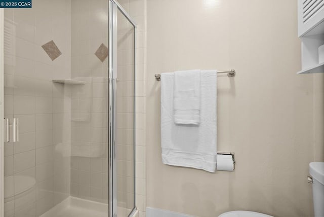 bathroom with toilet and an enclosed shower