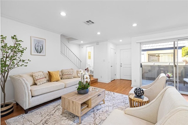 living room featuring wood-type flooring and crown molding