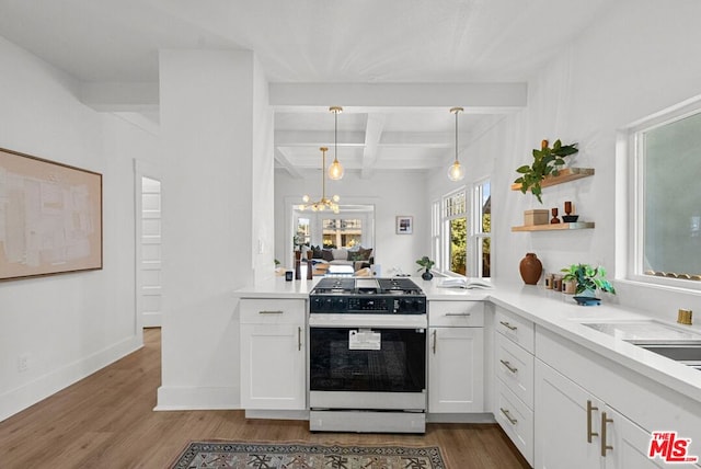 kitchen with beam ceiling, white cabinetry, stove, and hanging light fixtures