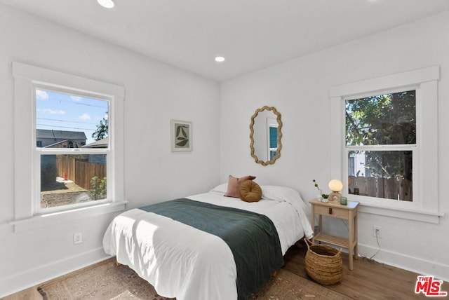 bedroom with wood-type flooring and multiple windows