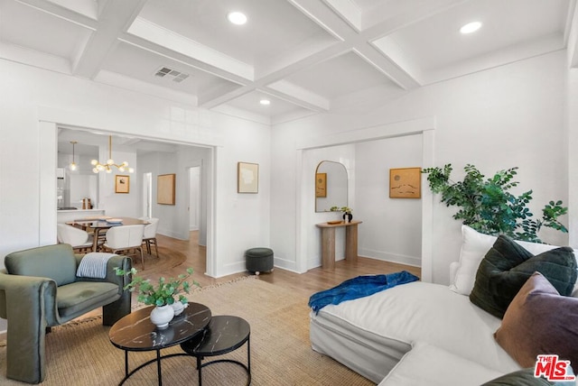 living room with beamed ceiling, a chandelier, light hardwood / wood-style flooring, and coffered ceiling