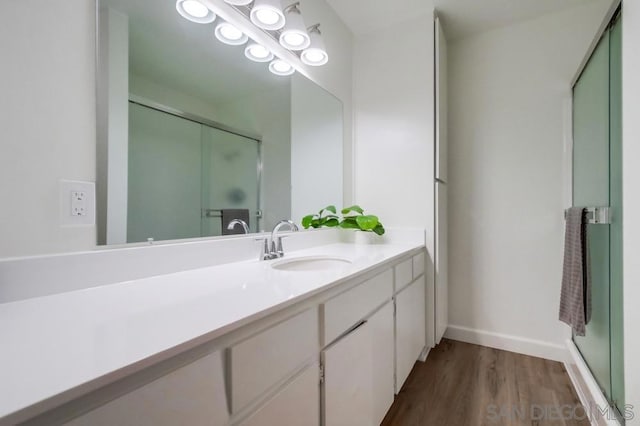 bathroom featuring hardwood / wood-style floors, vanity, and walk in shower