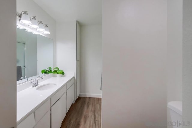 bathroom with vanity, toilet, and wood-type flooring