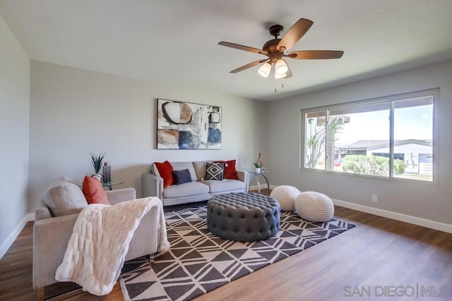 living room featuring ceiling fan and dark wood-type flooring