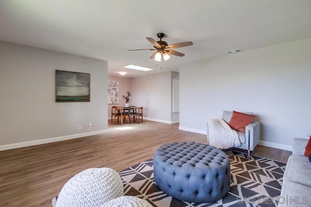 living area with hardwood / wood-style flooring and ceiling fan