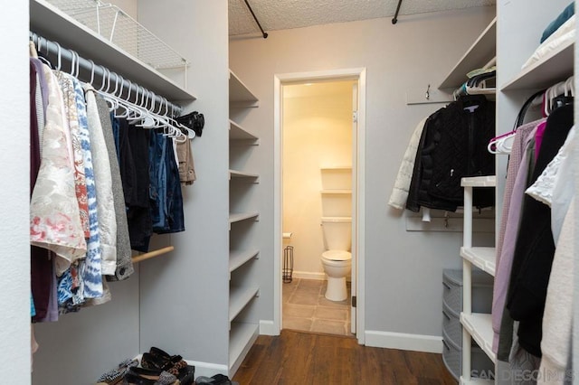 spacious closet with dark hardwood / wood-style floors