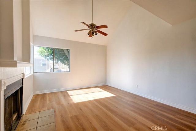 unfurnished living room featuring high vaulted ceiling, ceiling fan, and light hardwood / wood-style floors