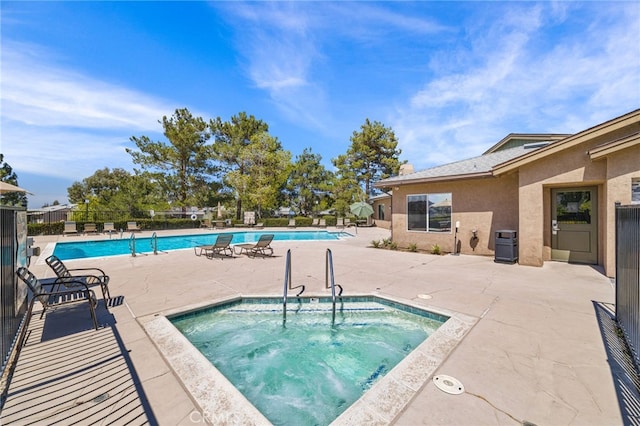 view of swimming pool with a patio area and a hot tub