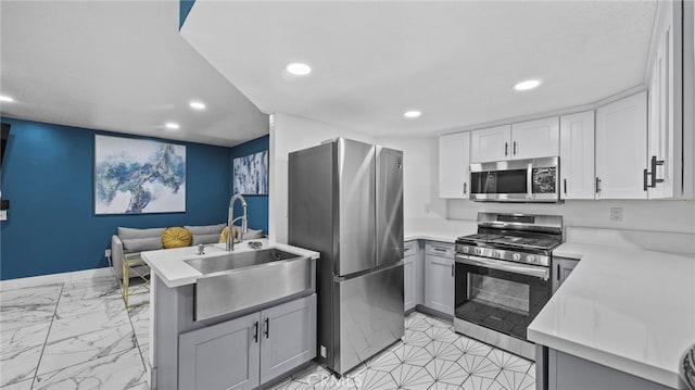 kitchen featuring kitchen peninsula, appliances with stainless steel finishes, gray cabinetry, and sink