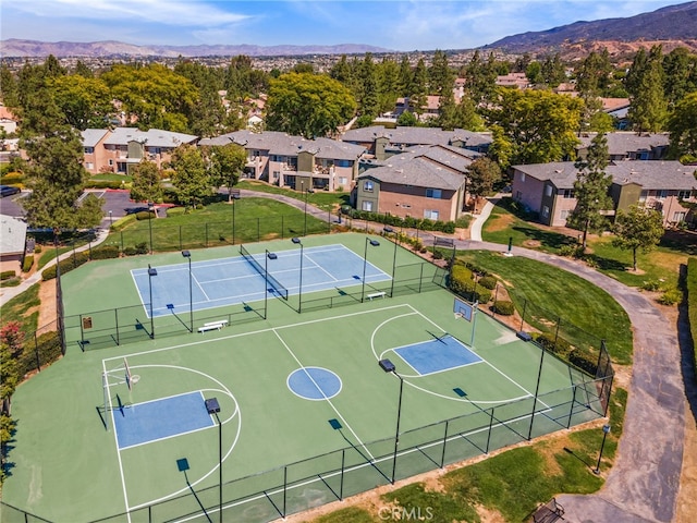 view of basketball court with a mountain view, a yard, and tennis court