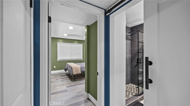 bathroom with a textured ceiling, hardwood / wood-style flooring, and walk in shower