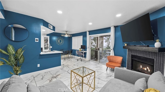 living room featuring a tiled fireplace and sink