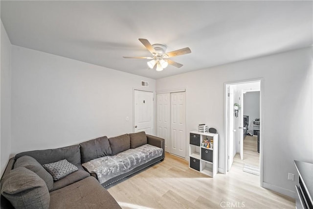 living room featuring ceiling fan and light hardwood / wood-style floors