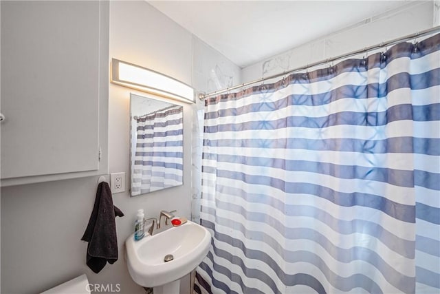 bathroom featuring a shower with curtain and sink