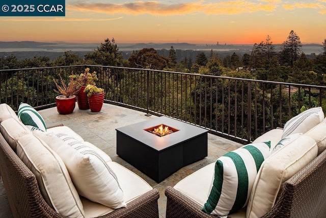 patio terrace at dusk featuring a fire pit