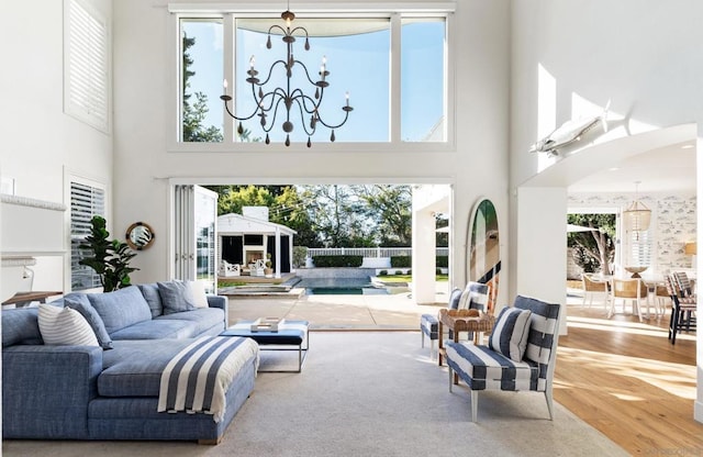 living room with a towering ceiling and a chandelier