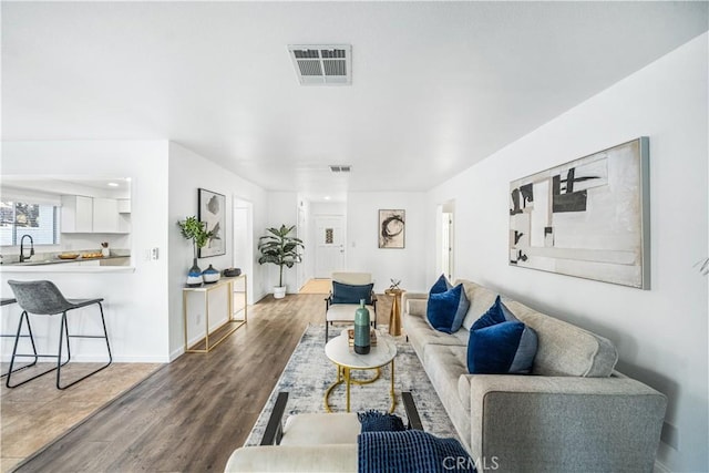 living room with dark hardwood / wood-style floors and sink