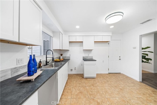 kitchen featuring white cabinetry, sink, and light tile patterned floors