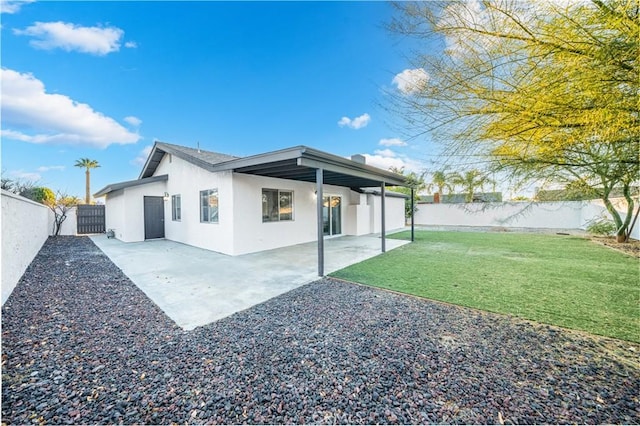 back of property with a patio area and a lawn