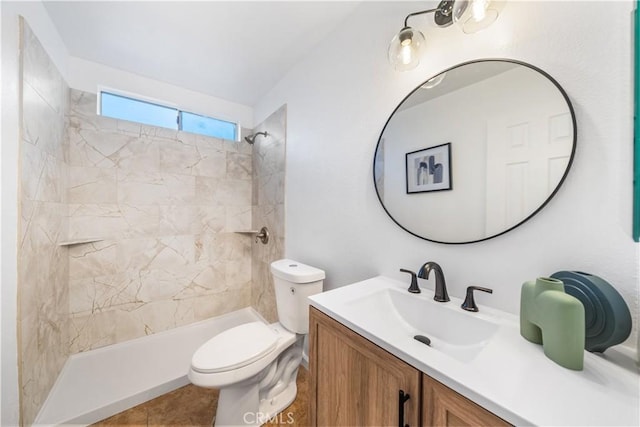 bathroom featuring tile patterned floors, vanity, toilet, and tiled shower