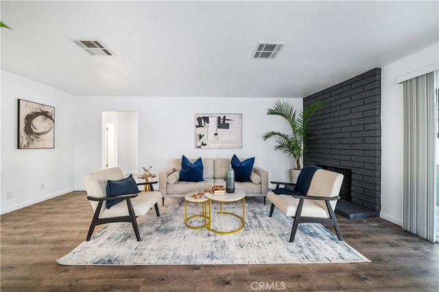 living room with a fireplace and dark wood-type flooring