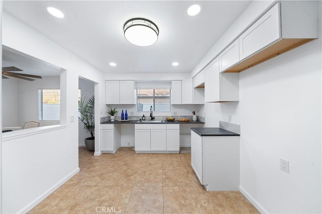 kitchen with plenty of natural light, white cabinetry, and sink