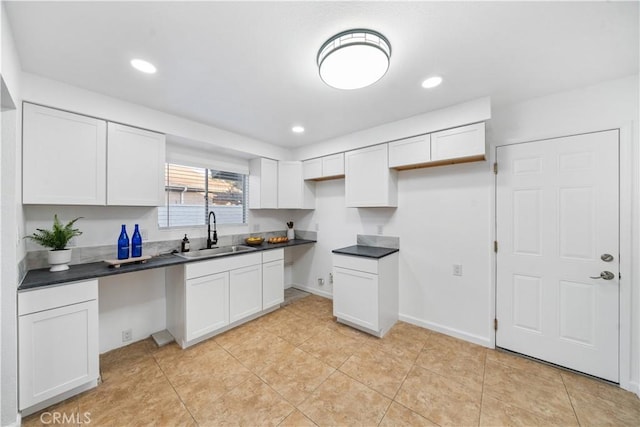 kitchen featuring white cabinetry, sink, and light tile patterned flooring