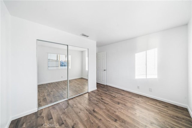 unfurnished bedroom with a closet and wood-type flooring