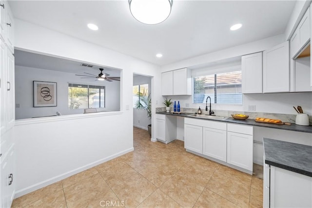 kitchen featuring light tile patterned floors, white cabinetry, ceiling fan, and sink