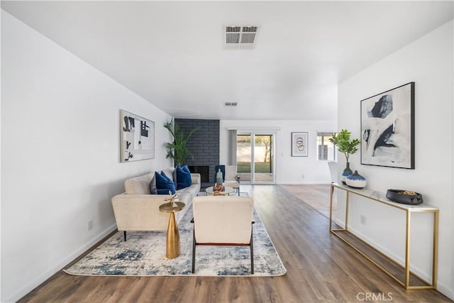 living room with a fireplace and wood-type flooring