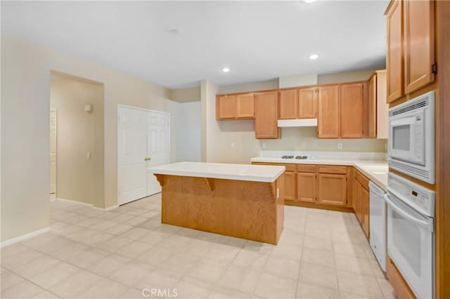 kitchen featuring white appliances, a kitchen island, and a breakfast bar area