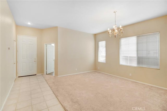 spare room featuring light tile patterned floors and a chandelier